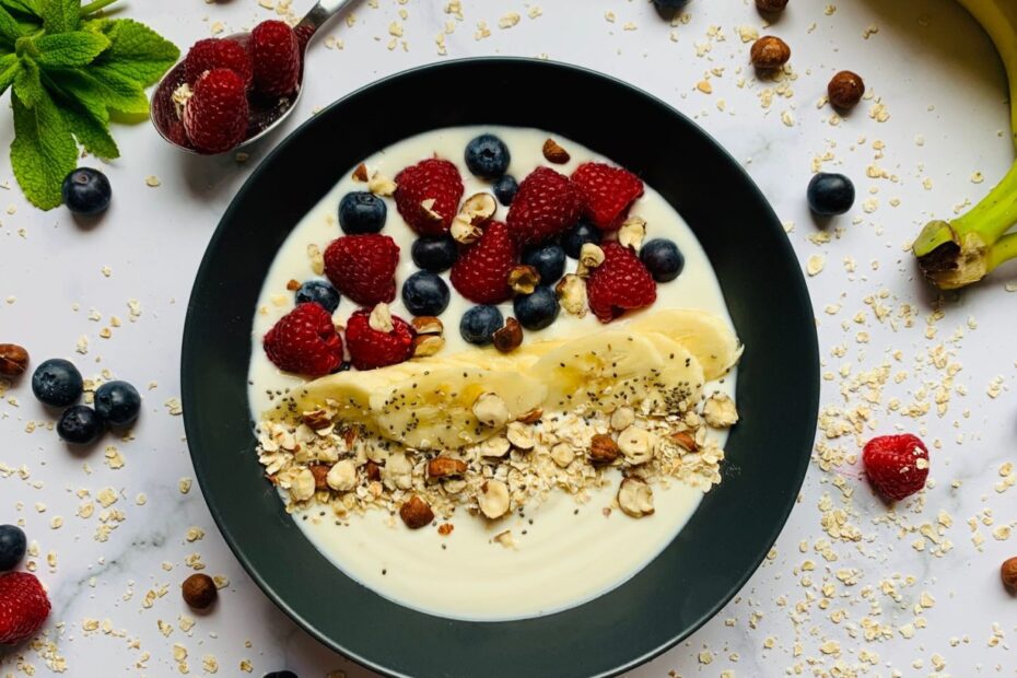 Ciotola di colazione con avena e frutta fresca su un tavolo chiaro
